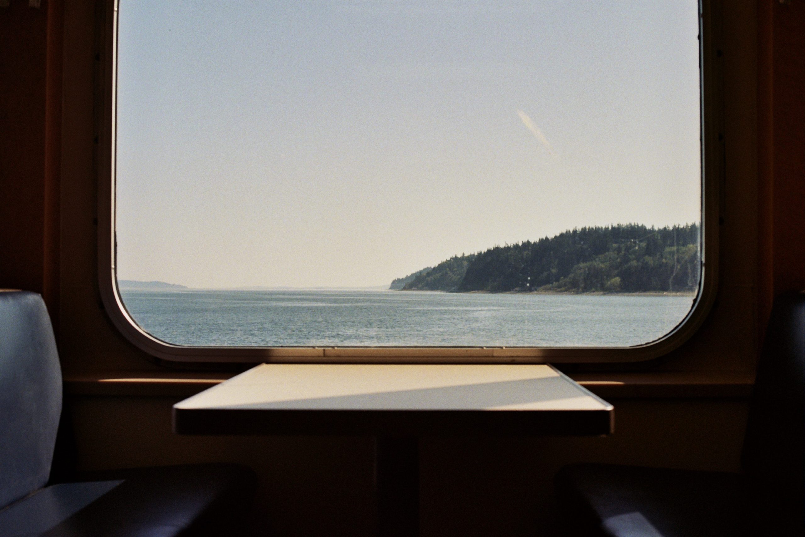 View from inside a Washington State Ferry traveling between islands, light filtering sofly in through the window.