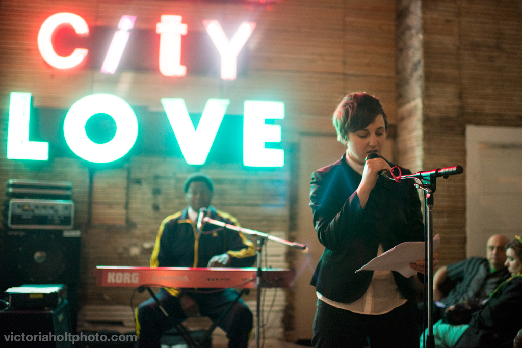 Jaimee hosting and legendary musician Dave Holden in the background. Photo by Victoria Holt.