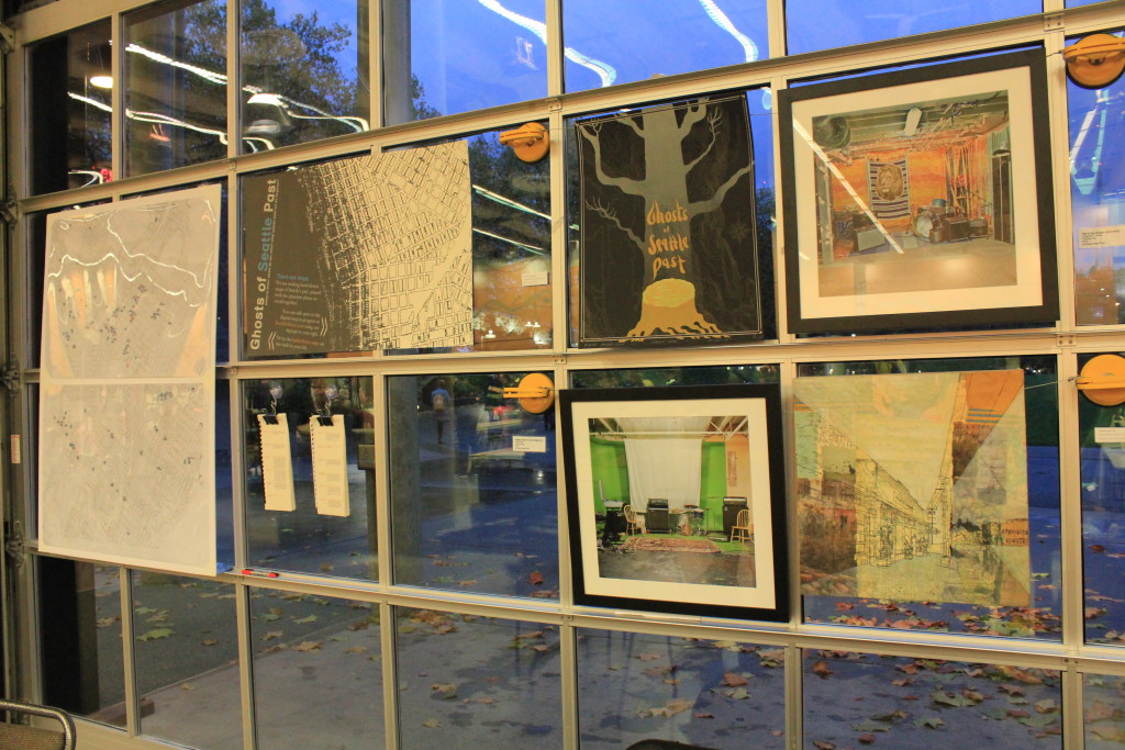 Key art elements from Ghosts of Seattle Past on display in a window at Short Run at Fisher Pavilion.